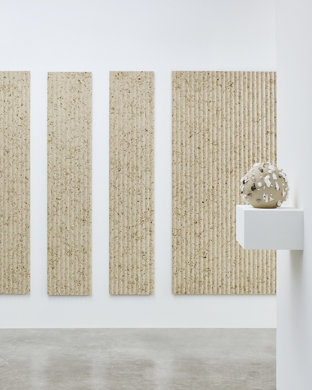 Panneau acoustique herbes naturelles Grass par Slalom, lin et foin panneau acoustique herbes naturelles Slalom Grass, quatre panneaux dans une galerie blanche