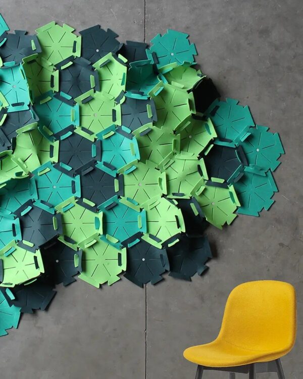 panneau acoustique modulaire Slalom Wave en feutre PET vert sur un mur en béton