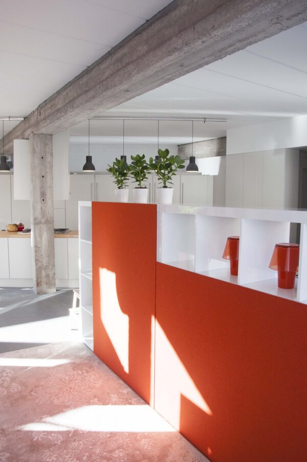 panneau acoustique mural BuzziBack orange fixé sur un meuble de rangement dans un bureau en loft
