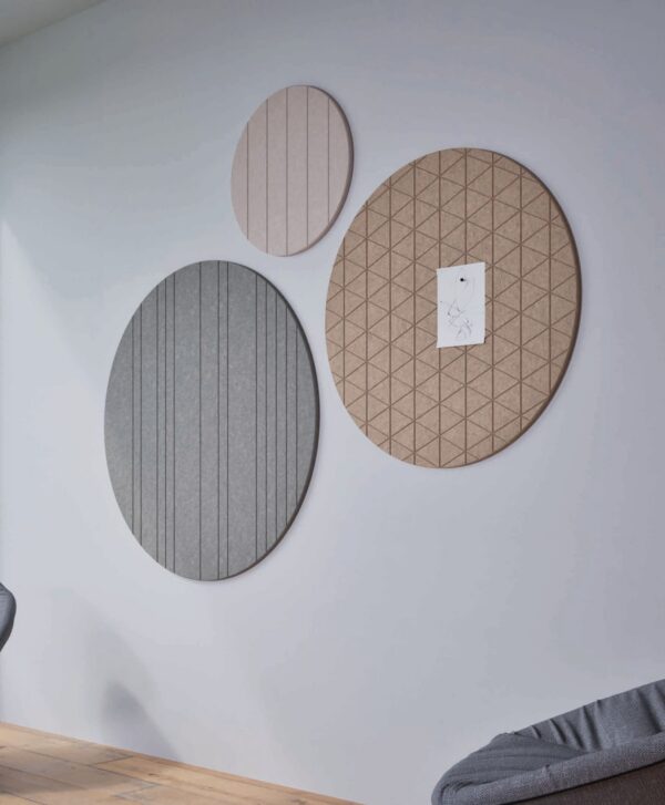 panneau acoustique rond Chameleon Round, trois disques gris, rose et naturel avec motifs sur un mur gris clair