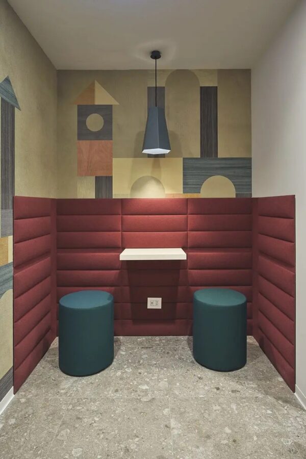 panneau acoustique thermoformé Slalom ECOwall bordeaux dans une alcove avec deux poufs