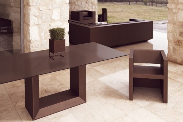 pot de fleurs extérieur Vela posé sur une table de terrasse, coloris bronze