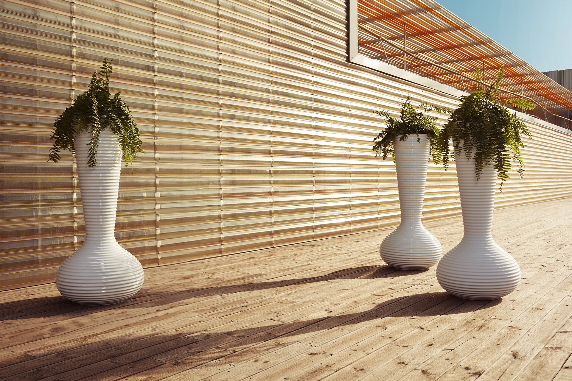 Pot géant Bloom en polyéthylène à stries par Eugeni Quitllet x Vondom pot géant extérieur Bloom en groupe sur une terrasse en bois