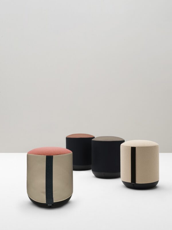 quatre poufs ronds Bi Bralco bicolores en tissu beige, noir et corail, ambiance de studio