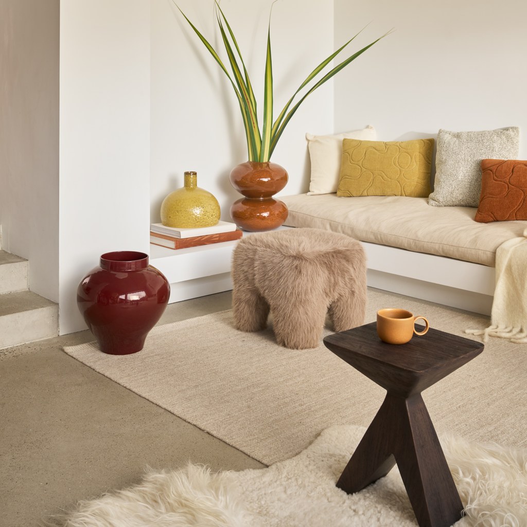 Pouf Kira par Urban Nature Culture, laine brossée ou fausse fourrure pouf Kira Urban Nature Culture, version fausse fourrure dans un salon près d'un canapé
