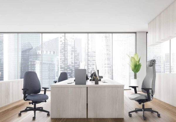 Siège ergonomique haut dossier et dossier moyen dans un open space lumineux