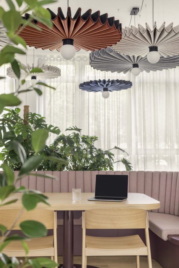 suspension acoustique BuzziPleat Light en feutres terracotta, gris et bleu au-dessus d une table de travail