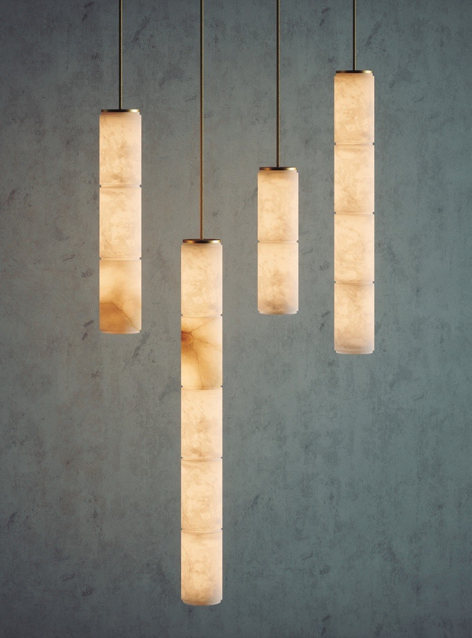 Suspension Boreal en albâtre par Robin Lamps suspension Boreal quatre colonnes en albâtre de longueurs différentes allumées sur un mur gris