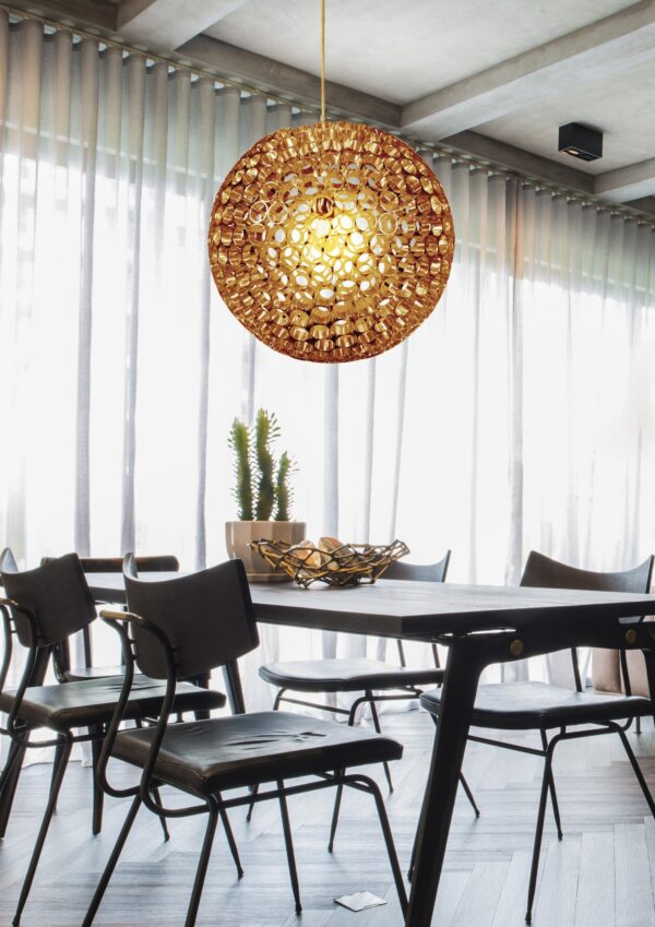 suspension boule cuivre ajourée au dessus d une table à manger