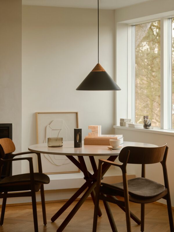 suspension Kinto noire au-dessus d une table ronde en bois