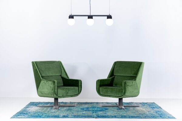 suspension LED BuzziSol Trio à trois globes au-dessus de deux fauteuils verts