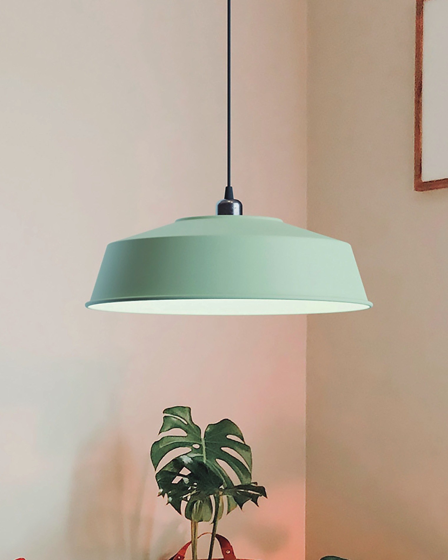 Suspension Mila en aluminium par Robin Lamps suspension Mila en finition verte sur mesure allumée au-dessus du coin salon avec plantes