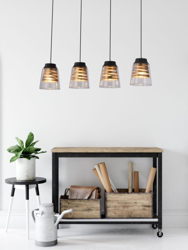 suspension spirale dorée 4 lumières au dessus d une console en bois