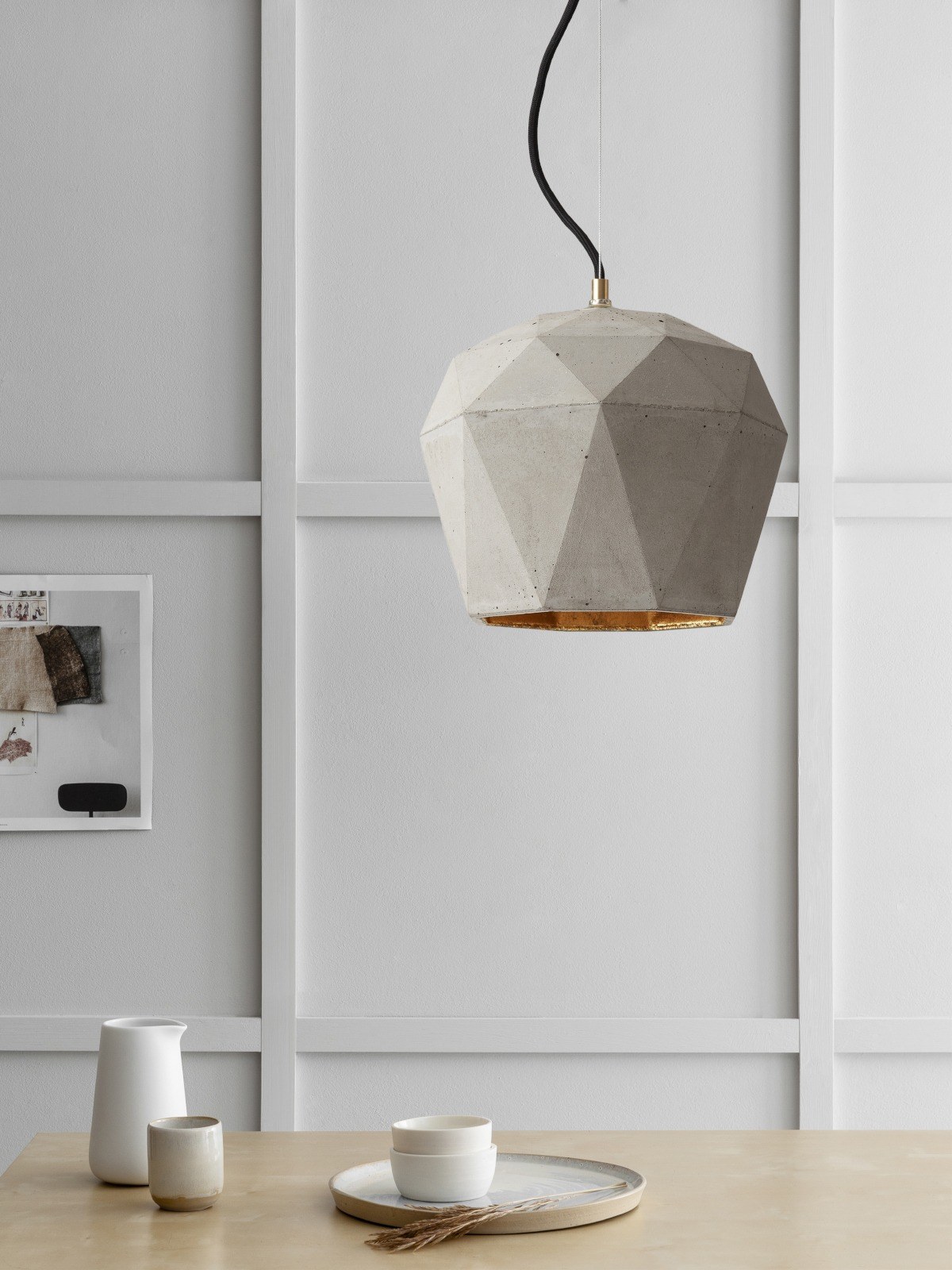 Suspension T4 béton clair triangulaire par Stefan Gant x Gant Lights Suspension T4 béton clair au-dessus d'une table dans une salle à manger