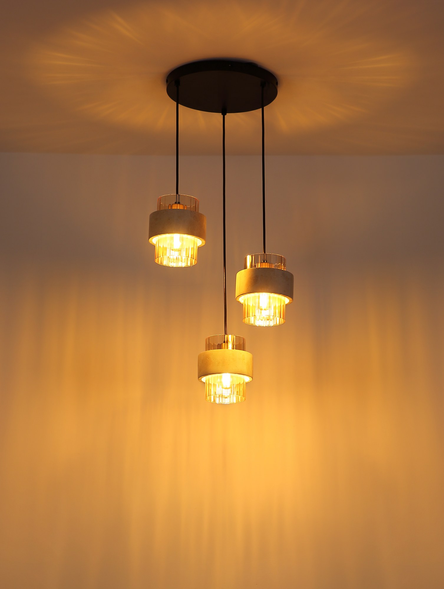 Suspension verre ambre travertin, 3 ou 4 lumières suspension verre ambre travertin 3 lumières allumée, lumière dorée sur le plafond