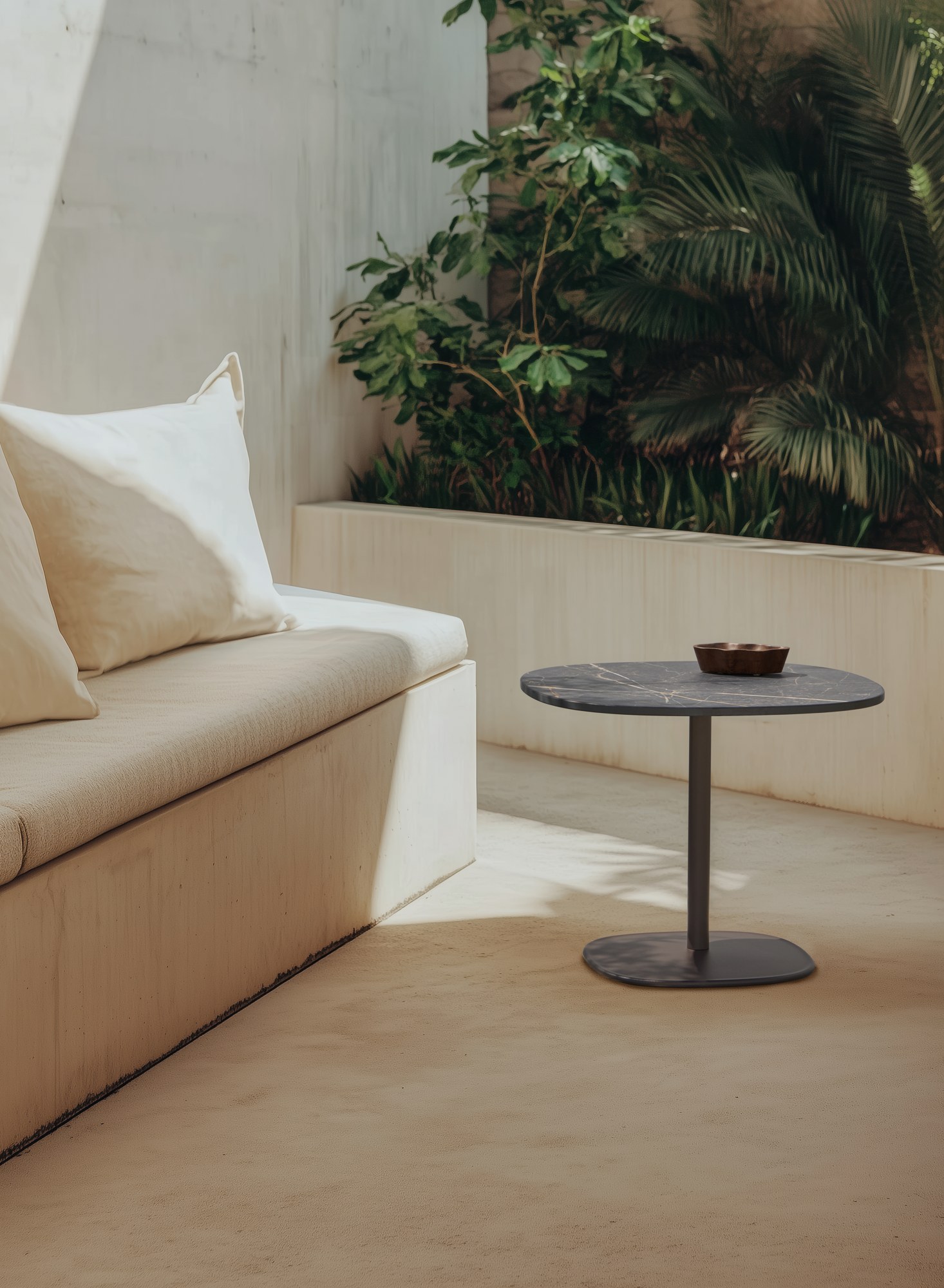 Table terrasse Floe Outdoor par Inclass, aluminium, tables d'appoint table terrasse Inclass Floe Outdoor en table appoint noire devant une banquette