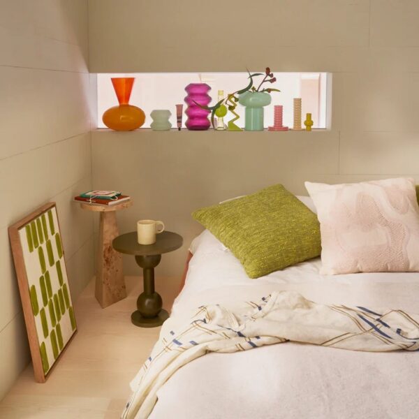 table d'appoint bois de loupe Mota Urban Nature Culture, au pied d'un lit avec une pile de livres sur le plateau