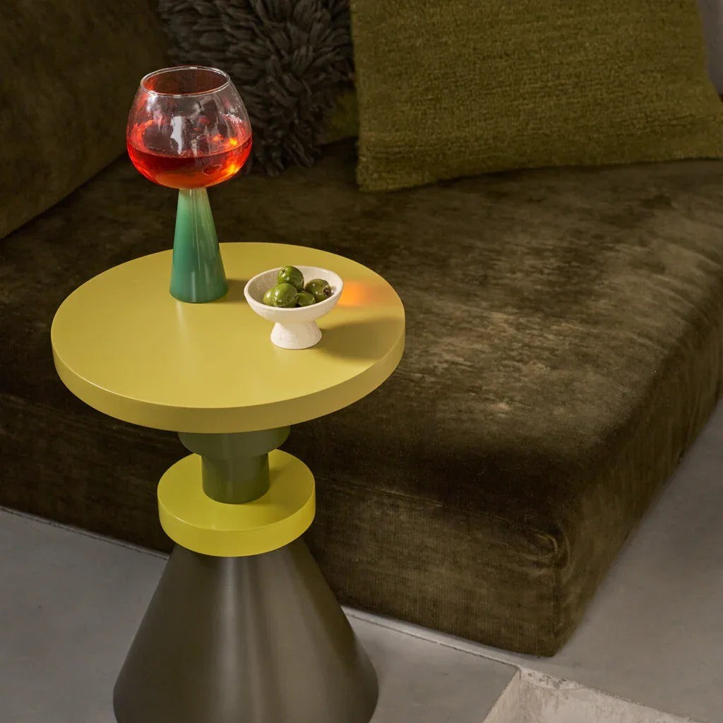 Table d'appoint Gjeng par Urban Nature Culture, manguier vert et jaune table d'appoint bois Gjeng Urban Nature Culture, avec un verre rouge et un bol d'olives sur le plateau