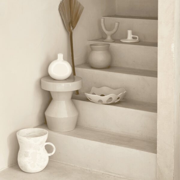 table d'appoint céramique Sculpturale Urban Nature Culture, coloris peyote dans un escalier en enduit clair avec des vases blancs