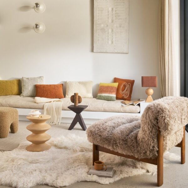 table d'appoint manguier Zira Urban Nature Culture, dans un salon avec un canapé crème et un fauteuil en peau de mouton
