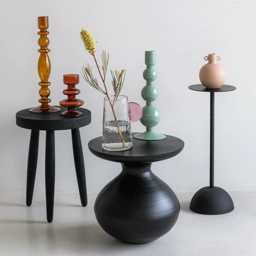Table d'appoint Tummy par Urban Nature Culture, métal, 3 coloris table d'appoint métal Tummy Urban Nature Culture, coloris noir avec des bougeoirs et un vase en verre