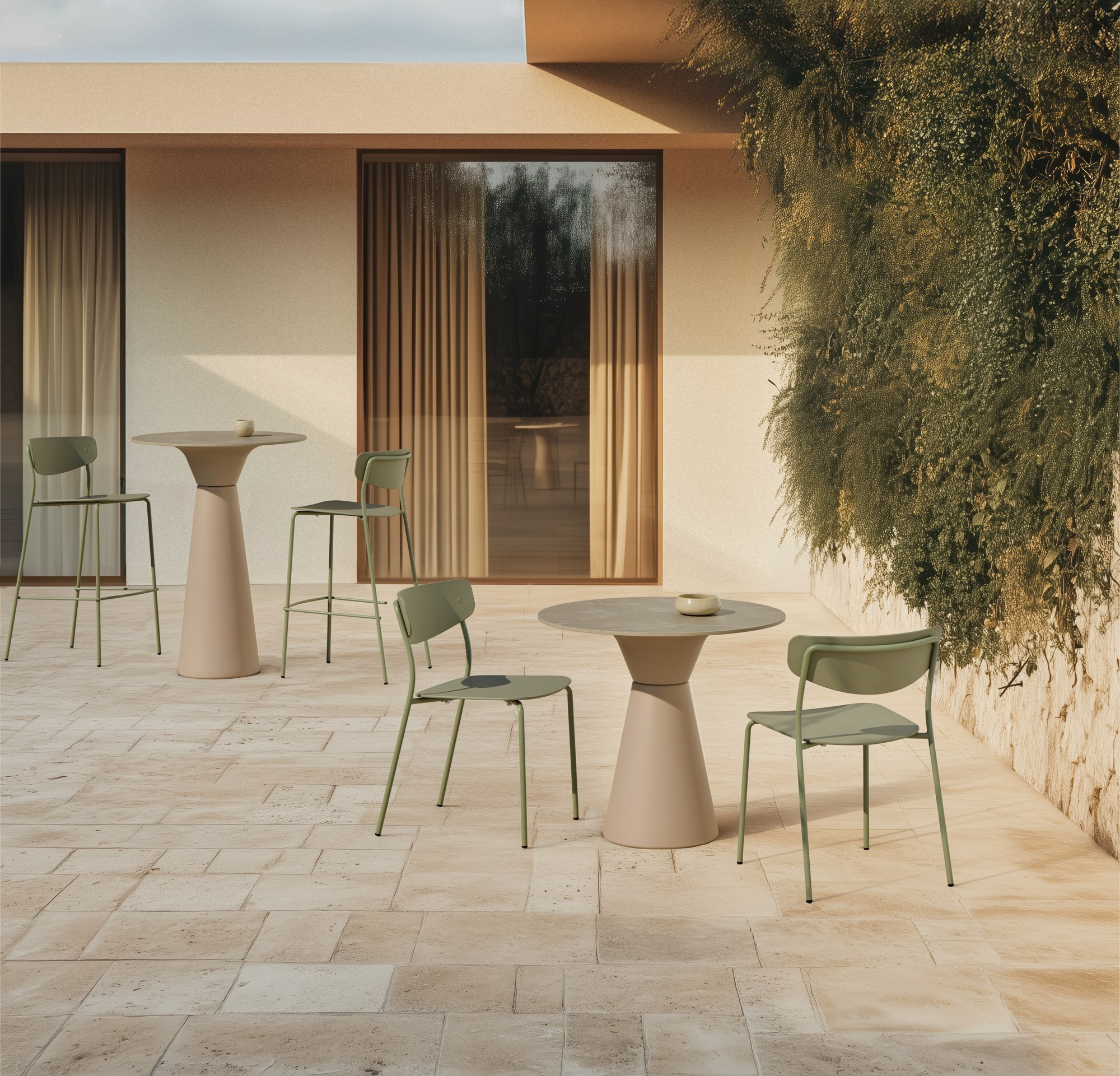 Table terrasse Essens Outdoor par Inclass, bases coniques en PE table terrasse Inclass Essens Outdoor beige avec chaises vertes dans une cour en situation