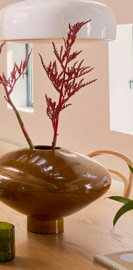 vase céramique Nala Urban Nature Culture, sur une table en bois avec de longues tiges rouges et d'autres vases
