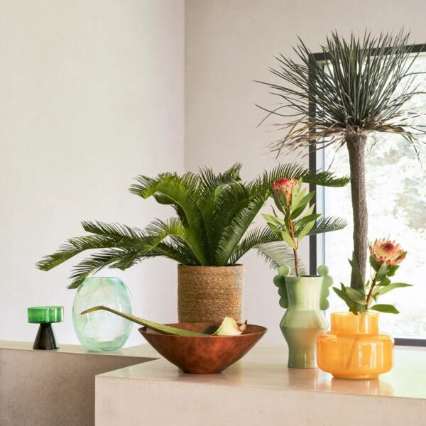 vase verre Nostra Urban Nature Culture, sur un meuble près de plantes et d'un bol en cuivre
