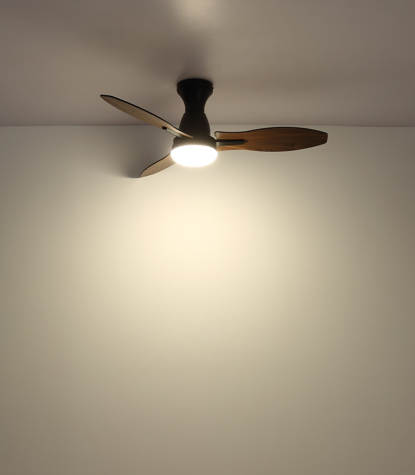 Ventilateur de plafond avec lumière LED et pales décor bois, Ø 107 cm ventilateur plafond 107 cm à trois pales décor bois foncé avec lumière LED, corps noir allumé au plafond, lumière LED chaude