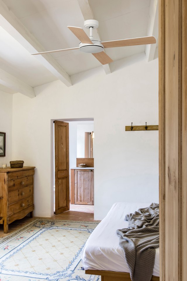 Ventilateur de plafond pour la chambre : comment bien le choisir ? Ventilateur de plafond Mallorca de Faro à pales en bois dans une chambre sous poutres